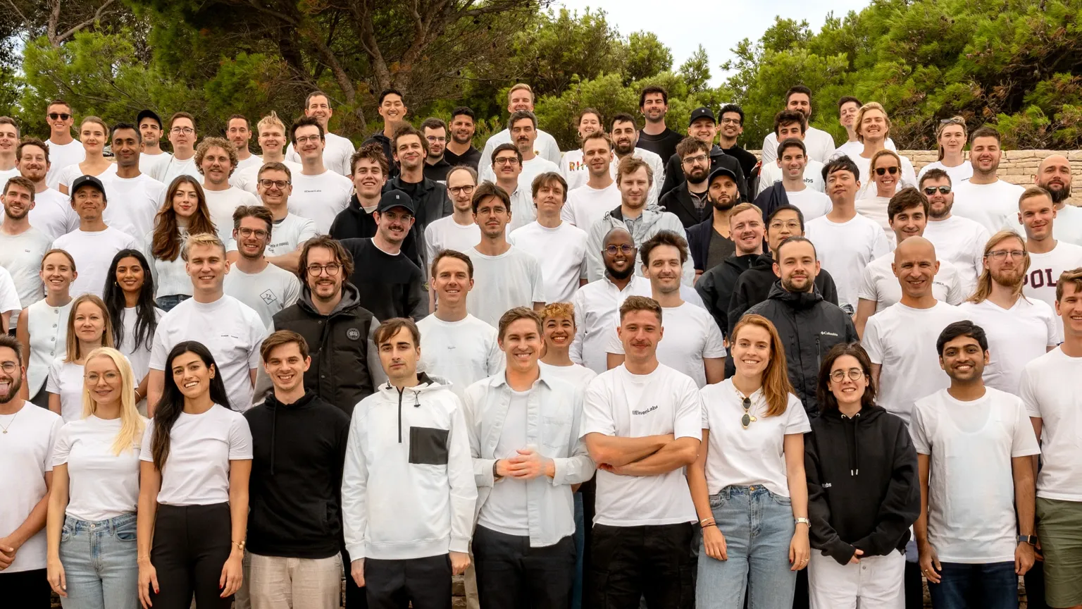 Most of the ElevenLabs team gathered on stone steps outdoors for a group photo at a company retreat.