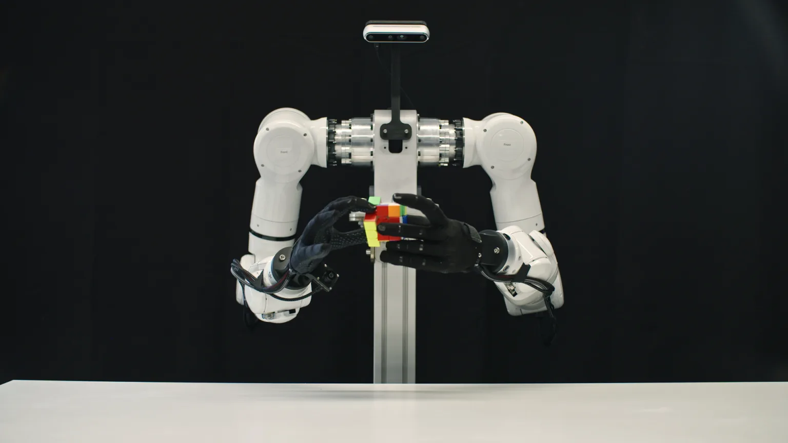 A bimanual Genesis robot with two human-like dexterous hands solving a Rubik's cube in mid-air.