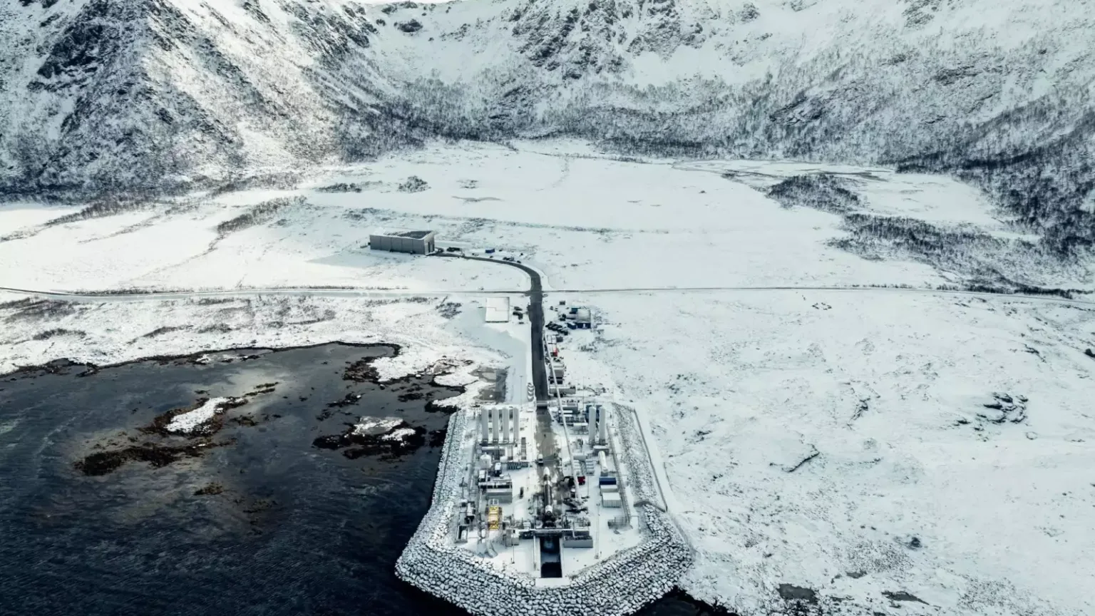 Aerial view of Isar Aerospace's launch complex on a snow-covered peninsula at Andøya Spaceport, Norway.