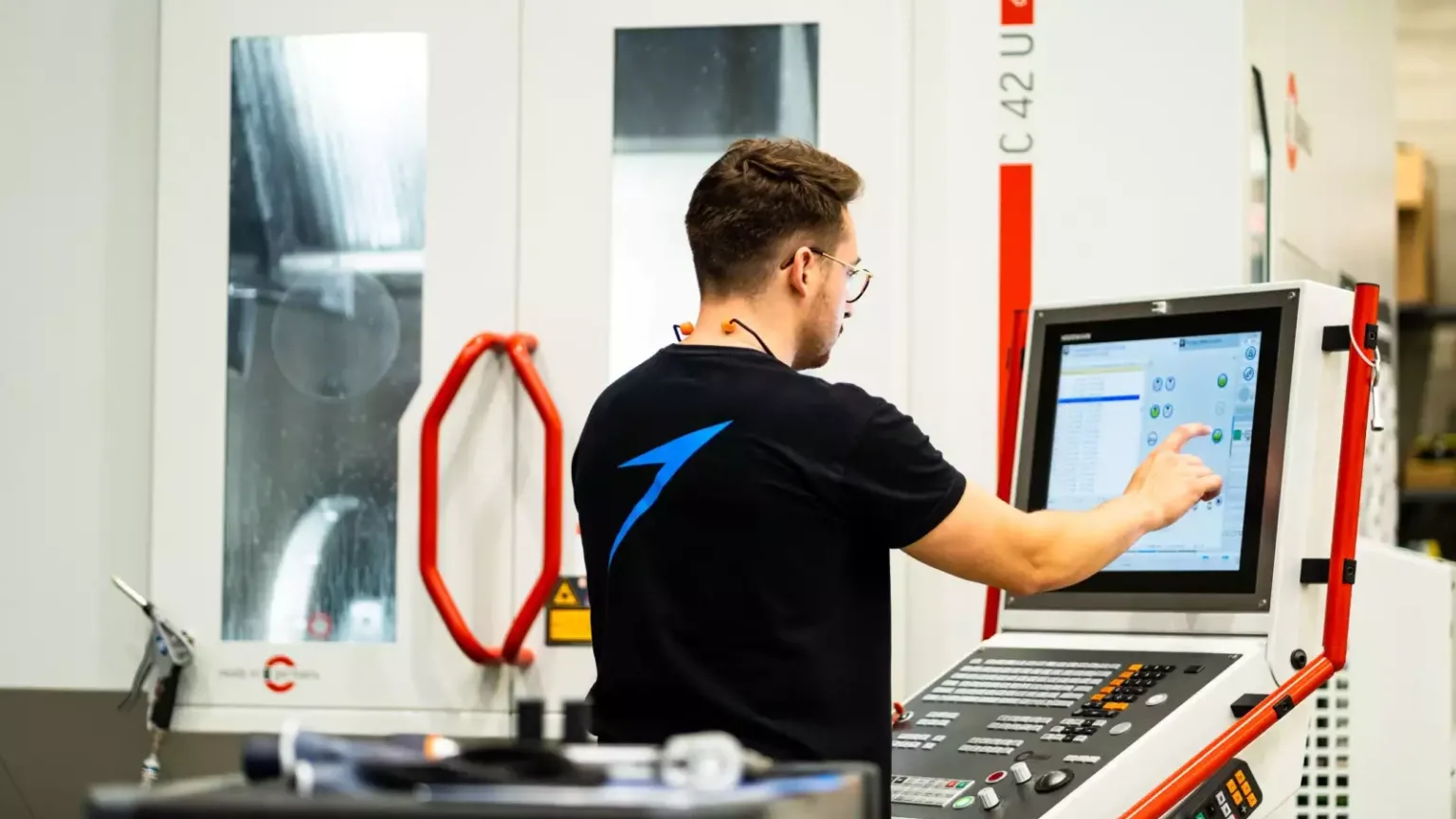 An Isar Aerospace technician operating a CNC machine on the production floor in Munich.