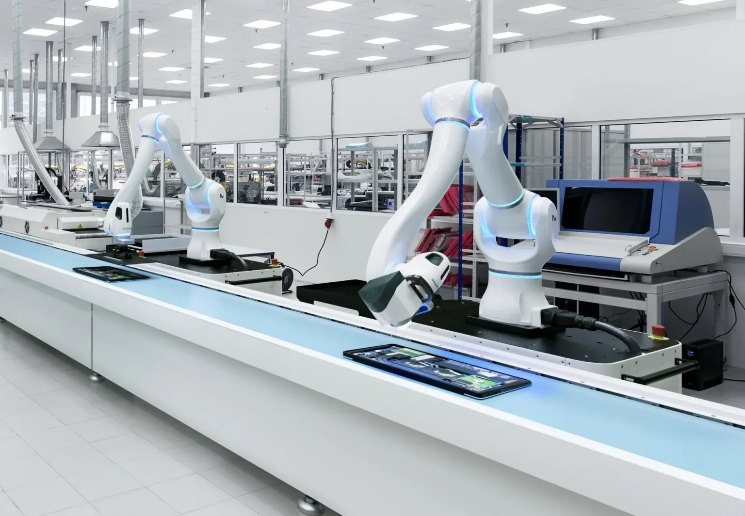 Two white MAiRA cognitive cobot arms with glowing blue rings working along an assembly line.