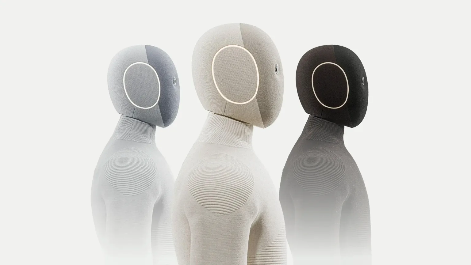 Three NEO Gamma humanoid robots in grey, cream and black knit bodysuits, shown from the chest up.
