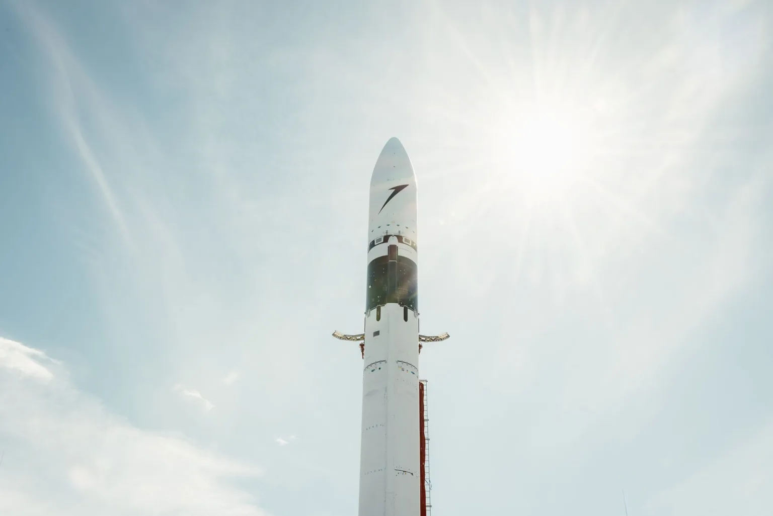 The payload fairing section of Isar Aerospace's Spectrum rocket standing upright outdoors.